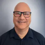 Stephen Simpson, founder of About Autism, smiling and wearing glasses